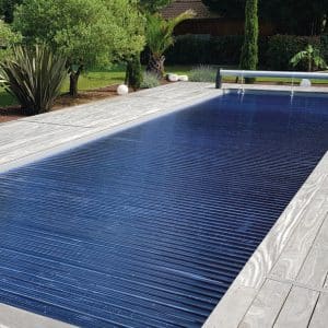 Lames bleues du volet Borvo Fixe déployées sur une piscine