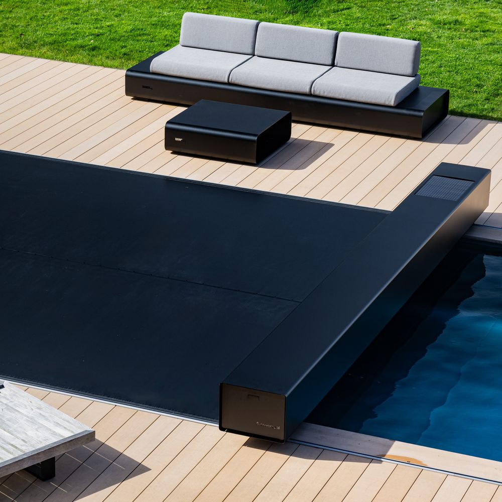 Couverture Coverseal noire déployée sur une piscine bordée d'une terrasse en bois