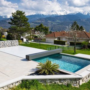 Couverture Coverseal ouverte sur une piscine face aux montagnes enneigées